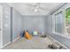 Bright, carpeted bedroom featuring a ceiling fan and a large window at 10819 Summerset Way, Parker, CO 80138