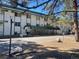 This is an exterior view of an apartment building with mature trees and a covered entry at 8824 E Florida Ave # 103, Denver, CO 80247