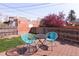 Backyard with a wood patio featuring blue chairs, a small black table, and a small tree at 3391 W 32Nd Ave, Denver, CO 80211