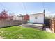 Backyard with a wood patio featuring blue chairs, a small black table, and a small grass yard at 3391 W 32Nd Ave, Denver, CO 80211