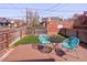 Backyard with a wood patio featuring blue chairs, a small black table, and a grass yard at 3391 W 32Nd Ave, Denver, CO 80211