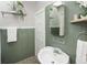 Bathroom with retro green tiling, a pedestal sink, and modern fixtures at 3391 W 32Nd Ave, Denver, CO 80211