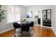 Elegant dining room with round glass table, black chairs, and hardwood floors at 3391 W 32Nd Ave, Denver, CO 80211