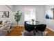 Dining area features a round glass table, four black chairs, and hardwood flooring at 3391 W 32Nd Ave, Denver, CO 80211