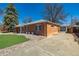 Brick home featuring a long driveway leading to a detached garage at 938 Racine St, Aurora, CO 80011