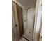 A compact standing shower featuring white tiling, glass door, and shower head at 938 Racine St, Aurora, CO 80011