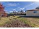 Fenced backyard featuring a mature tree, lawn, and a brick house exterior at 190 Hemlock St, Broomfield, CO 80020