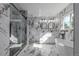 Luxurious bathroom with marble tiling, a glass-enclosed shower, double vanity, and modern soaking tub at 190 Hemlock St, Broomfield, CO 80020