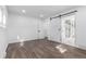 Bedroom featuring wood floors, natural light, and sliding barn door leading to the bathroom at 190 Hemlock St, Broomfield, CO 80020