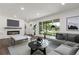 Staged living room with wood floors, fireplace, and a large window showcasing the front yard at 190 Hemlock St, Broomfield, CO 80020