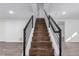 Stairway with wood steps, black metal railing, and neutral wall paint at 190 Hemlock St, Broomfield, CO 80020