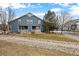 Exterior view showcasing the backyard with a patio, lawn, and mature trees, perfect for outdoor enjoyment at 4674 Flower St, Wheat Ridge, CO 80033