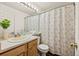 Full bathroom featuring a flower-patterned shower curtain and wooden vanity at 4674 Flower St, Wheat Ridge, CO 80033