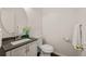 Cozy bathroom featuring a stylish vanity, round mirror, and modern fixtures at 4674 Flower St, Wheat Ridge, CO 80033