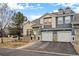 Charming two-story townhouse features a two-car garage, stone accents, and a well-maintained front yard at 4674 Flower St, Wheat Ridge, CO 80033