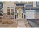 Welcoming front porch with stone accents and a glass door provides an inviting entrance to this home at 4674 Flower St, Wheat Ridge, CO 80033