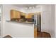 Modern kitchen with stainless steel appliances, wood cabinets, and a functional breakfast bar for casual dining and entertaining at 4674 Flower St, Wheat Ridge, CO 80033