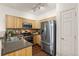 Well-equipped kitchen with stainless steel appliances, wood cabinets, and a stylish backsplash for modern cooking at 4674 Flower St, Wheat Ridge, CO 80033