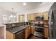 The kitchen features wood cabinets, stainless steel appliances, and a breakfast bar connecting to the dining area at 4674 Flower St, Wheat Ridge, CO 80033