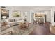 Bright living room with modern furnishings, hardwood floors, and view into an adjacent dining area and the kitchen at 4674 Flower St, Wheat Ridge, CO 80033