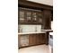 Elegant wet bar with dark wood cabinetry, wine cooler, and granite countertop at 335 Clayton St, Denver, CO 80206