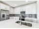 Close up of kitchen island with stainless steel sink, appliances, and gray backsplash at 2098 Peachleaf Loop, Castle Rock, CO 80108