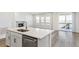 Kitchen island with stainless steel appliances and an open living area with fireplace at 2098 Peachleaf Loop, Castle Rock, CO 80108