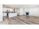 Bright living room with wood floors, a modern fireplace, and a white kitchen with stainless steel appliances at 2098 Peachleaf Loop, Castle Rock, CO 80108