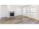 Living area with wood floors, fireplace, bright windows, and a white door leading to other rooms at 2098 Peachleaf Loop, Castle Rock, CO 80108