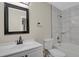 Tiled bathroom with white cabinets and a black framed mirror at 14308 E Whitaker Pl # 114, Aurora, CO 80015