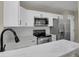 Modern kitchen with white cabinets, stainless steel appliances, and quartz countertops at 14308 E Whitaker Pl # 114, Aurora, CO 80015