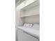 Well-equipped laundry area features a washer, dryer, and shelving for ample storage at 14308 E Whitaker Pl # 114, Aurora, CO 80015
