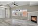 Bright living room with fireplace, ceiling fan, wood floors, and large windows at 14308 E Whitaker Pl # 114, Aurora, CO 80015