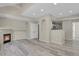 Spacious living room and partial view of kitchen, featuring wood floors and fireplace at 14308 E Whitaker Pl # 114, Aurora, CO 80015