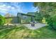 Spacious backyard with a large green lawn, concrete patio, fire pit, and mature trees at 2211 Sherman St, Longmont, CO 80501