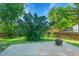 Large concrete patio with a fire pit, surrounded by lush green lawn and mature trees at 2211 Sherman St, Longmont, CO 80501