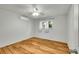 Well-lit bedroom with ceiling fan, wood-look flooring, a window, and air conditioning unit at 2211 Sherman St, Longmont, CO 80501