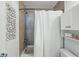 Tiled bathroom shower area with a white shower curtain and storage cabinets at 4740 Milwaukee St, Denver, CO 80216