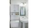 Bright bathroom featuring a pedestal sink, mirror, and a white cabinet for storage at 4740 Milwaukee St, Denver, CO 80216