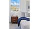Cozy bedroom with a bright window, stylish nightstand, and comfortable bedding with a blue blanket at 4740 Milwaukee St, Denver, CO 80216
