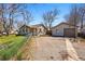 Home exterior with yard space, detached garage, and gravel parking area at 4740 Milwaukee St, Denver, CO 80216