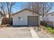 Exterior of detached garage with gray doors and a concrete driveway at 4740 Milwaukee St, Denver, CO 80216