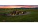 Home on sprawling green lot with colorful sunset, blue skies and green lawn at 15958 Shadow Mountain Ranch Rd, Larkspur, CO 80118