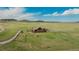 Expansive aerial view showcases ranch home on a large green lot with winding roads at 15958 Shadow Mountain Ranch Rd, Larkspur, CO 80118