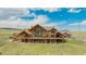 Beautiful exterior elevation showcasing the stone facade and large deck with a beautiful lawn at 15958 Shadow Mountain Ranch Rd, Larkspur, CO 80118