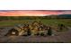Beautiful stone home with a circular driveway situated on a spacious lot at sunset at 15958 Shadow Mountain Ranch Rd, Larkspur, CO 80118