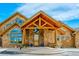 Inviting front entrance with stone accents, a covered porch, and decorative plants at 15958 Shadow Mountain Ranch Rd, Larkspur, CO 80118