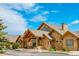 Charming stone home with a welcoming front porch and well-manicured landscaping at 15958 Shadow Mountain Ranch Rd, Larkspur, CO 80118