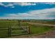 Scenic landscape featuring a wooden fence, rolling hills, and a stunning mountain range in the distance at 15958 Shadow Mountain Ranch Rd, Larkspur, CO 80118