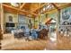 Expansive living room with exposed beams, stone fireplace, and open layout leading to the kitchen at 15958 Shadow Mountain Ranch Rd, Larkspur, CO 80118